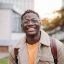 Portrait Of Positive Happy African American Male Student Standing In University campus